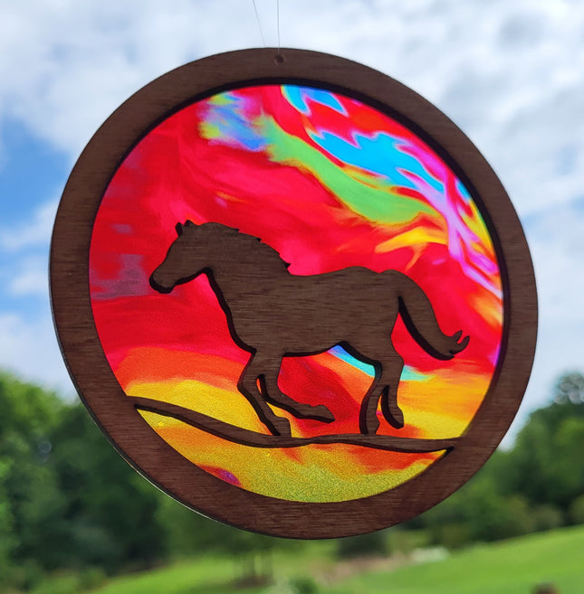 Circular, wooden suncatcher with a horse running. Transparent acrylic background with multi colored "fire".