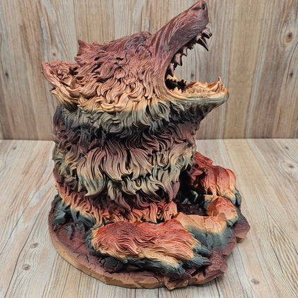side view of 3d printed dire wolf dice tower showing the red, black, and gold gradient when printed. The wolf has more red and brown tones in this particular print. 