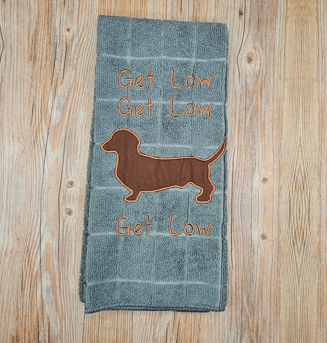image of a gray embroidered polyester kitchen towel. It says "Get Low" 3 times and has a brown dachshund silhouette