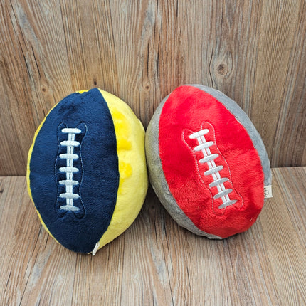 image of 2 plush football dog toys in blue/yellow and red/gray with embroidered laces