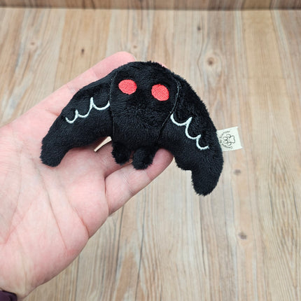 image of mothman cat toy in an adult hand to show sizing