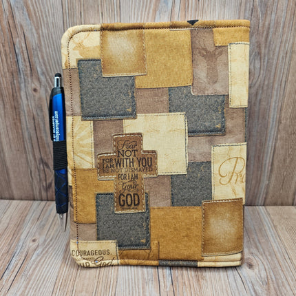 Patchwork notebook with motivational text on a wooden surface
