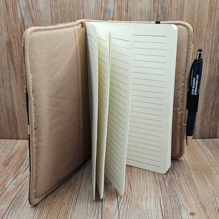Open notebook with lined pages on a wooden surface