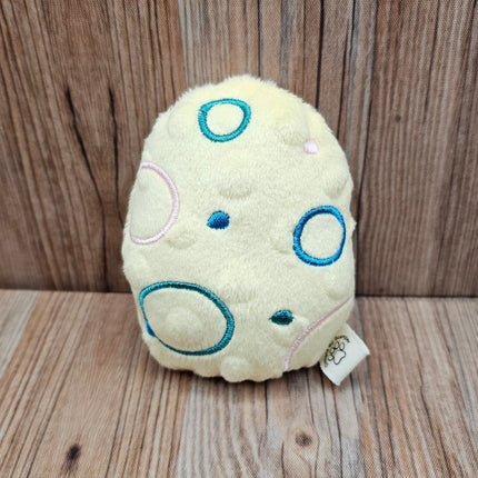 yellow plush easter egg cat toy with embroidered circles.