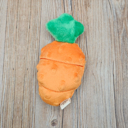 Plush carrot cat toy with a green top on a wooden surface