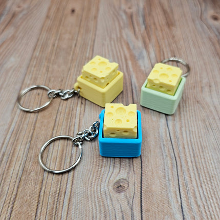 Cheese-shaped keychains on a wooden surface