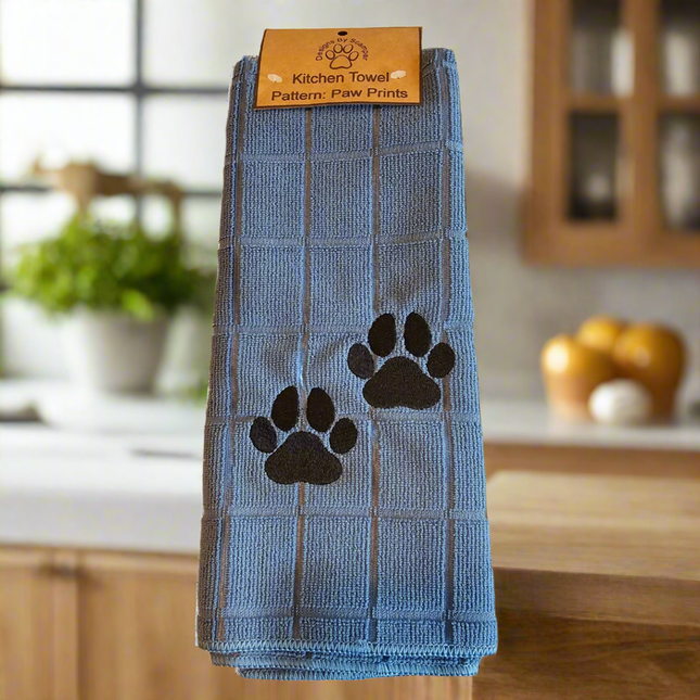 100% polyester, light blue kitchen towel with 2 embroidered black paw prints