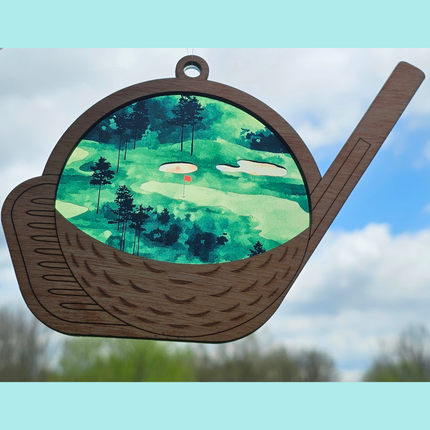 transparent acrylic suncatcher with a golf theme. Suncatcher has a wooden top layer that is in the shape of a golf club and ball. Details are laser etched