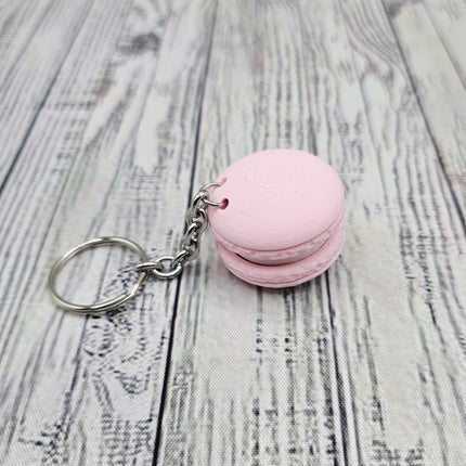 Pink macaron-shaped keychain on a wooden surface